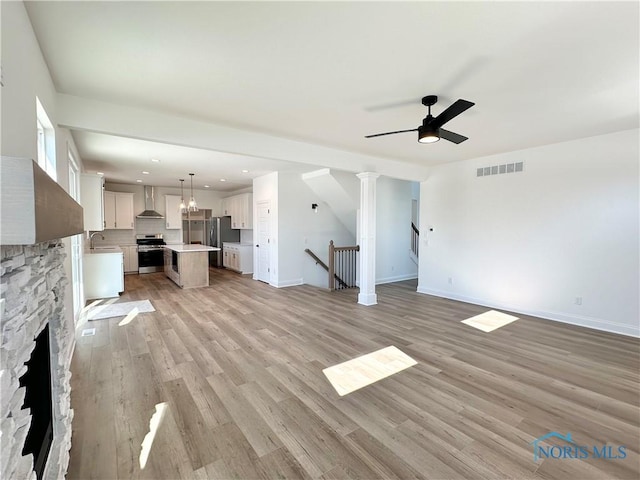 unfurnished living room with a fireplace, recessed lighting, visible vents, light wood-style flooring, and ceiling fan