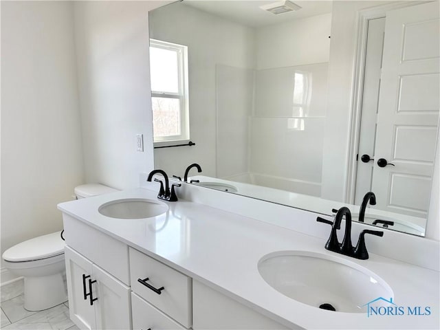 bathroom featuring toilet, marble finish floor, a sink, and visible vents