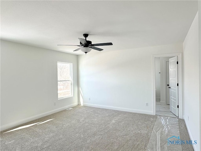 spare room featuring baseboards, ceiling fan, and light colored carpet