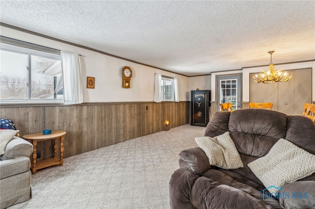 living room featuring ornamental molding, light carpet, a chandelier, and a textured ceiling