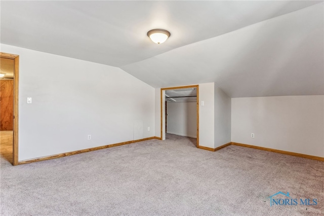 additional living space with lofted ceiling and light carpet