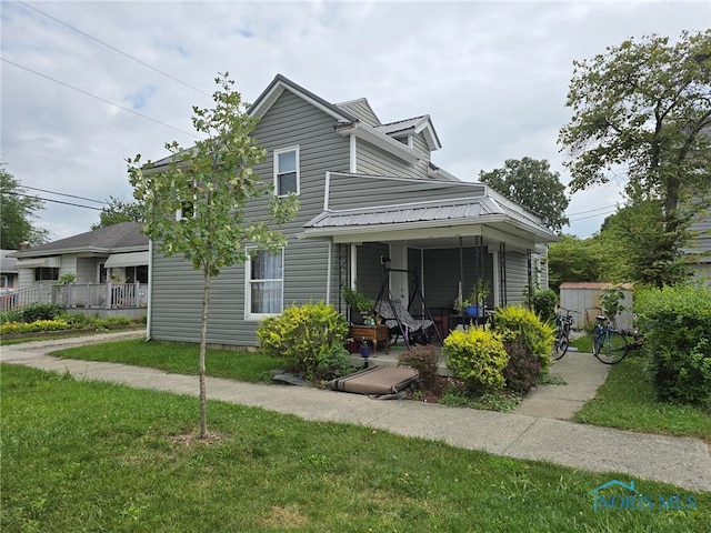 view of front of home with covered porch and a front lawn