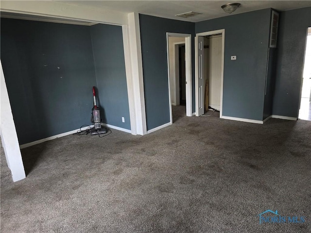 spare room featuring dark carpet