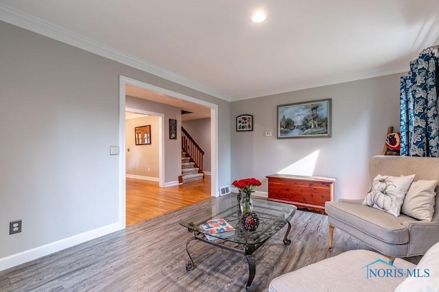 living area with wood finished floors, visible vents, baseboards, stairs, and ornamental molding