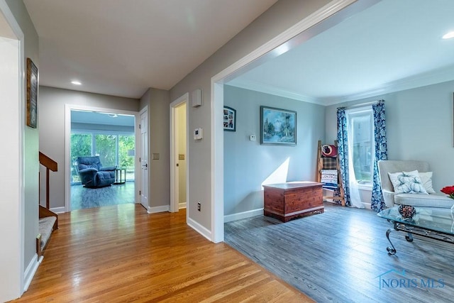 hall with baseboards, light wood-style flooring, stairs, crown molding, and recessed lighting