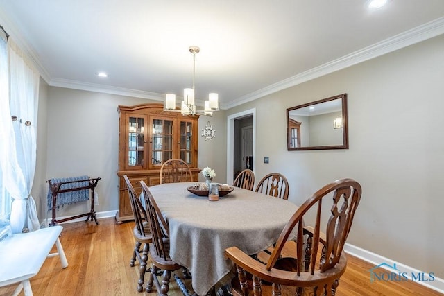 dining space with ornamental molding, light wood-type flooring, and baseboards