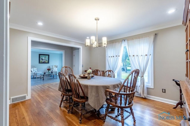 dining area with ornamental molding, light wood-type flooring, and visible vents