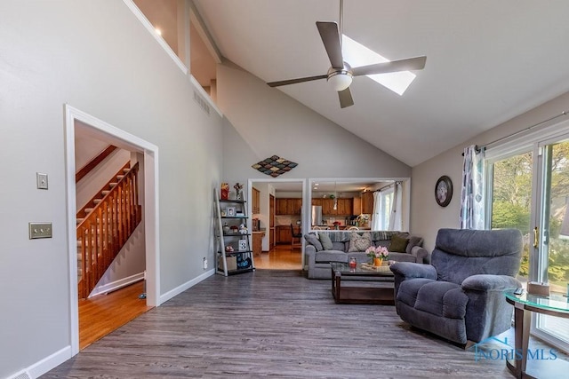 living room with visible vents, ceiling fan, wood finished floors, stairs, and high vaulted ceiling