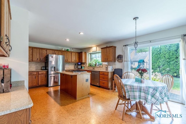 kitchen with brown cabinetry, stainless steel appliances, and light countertops