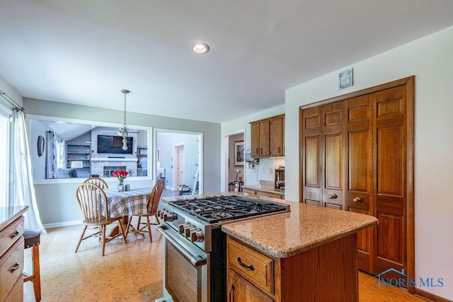 kitchen with pendant lighting, brown cabinets, baseboards, and gas range