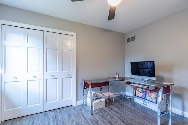 office with a ceiling fan, visible vents, baseboards, and wood finished floors