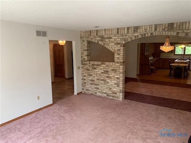 interior space with a textured ceiling and carpet flooring