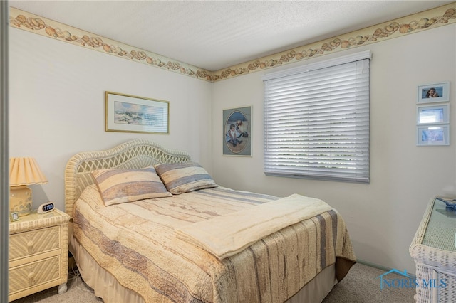 carpeted bedroom with a textured ceiling and multiple windows