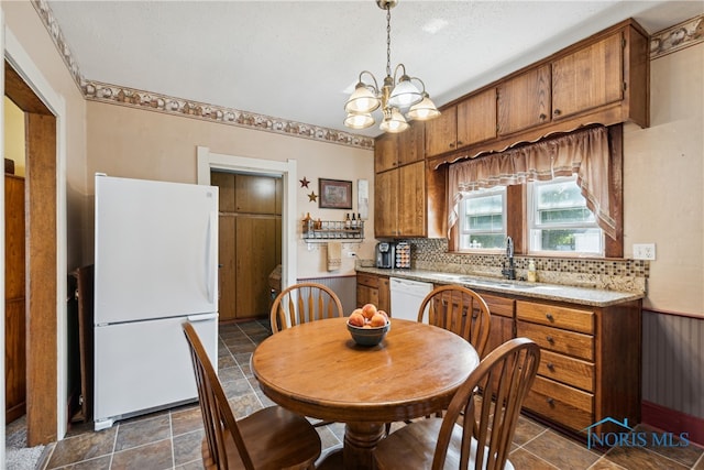 tiled dining room with sink and a chandelier