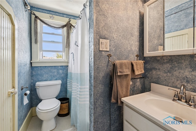 bathroom with toilet, vanity, and a shower with curtain