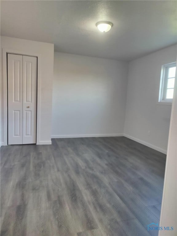 unfurnished room featuring dark wood finished floors and baseboards