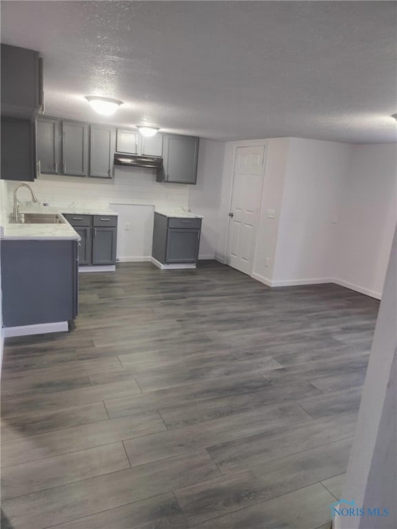 kitchen featuring gray cabinetry, sink, a textured ceiling, and dark hardwood / wood-style floors