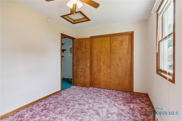 unfurnished bedroom with ceiling fan, a closet, multiple windows, and carpet