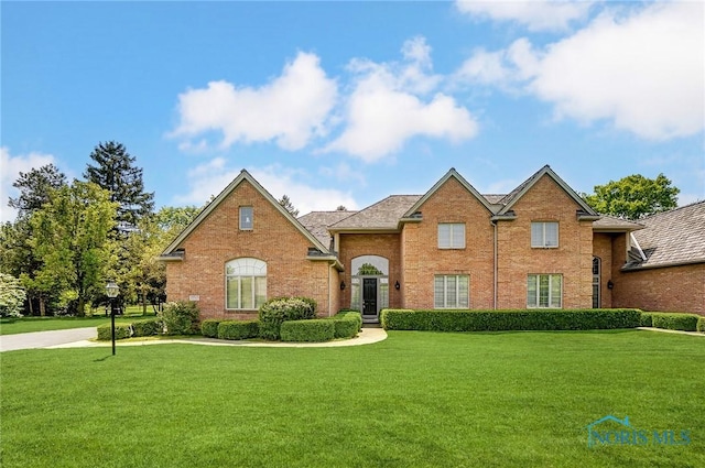 traditional home featuring brick siding and a front yard