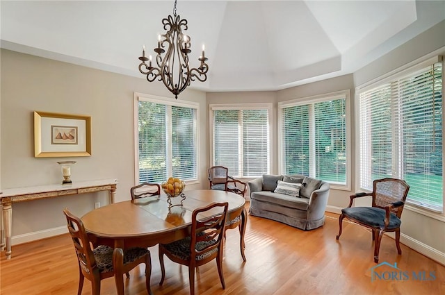 dining room with a notable chandelier, light wood-type flooring, and baseboards