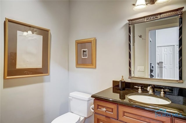 half bath featuring vanity and toilet