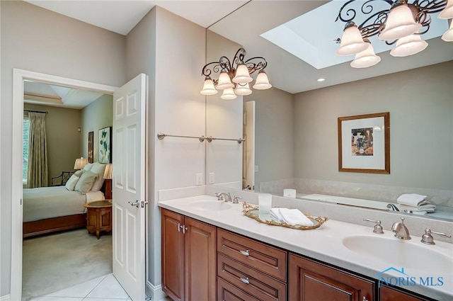 bathroom featuring a sink, double vanity, a skylight, and connected bathroom