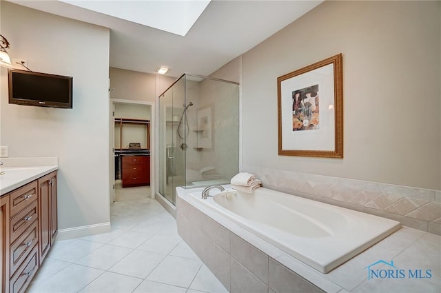 bathroom featuring a skylight, vanity, a shower stall, a bath, and tile patterned floors