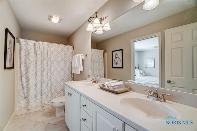 ensuite bathroom with double vanity, tile patterned floors, a sink, and ensuite bathroom