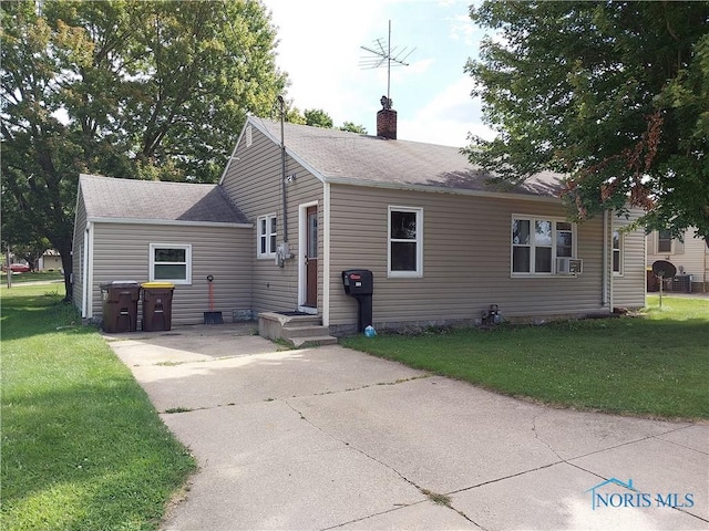 view of front of house with a front lawn and cooling unit