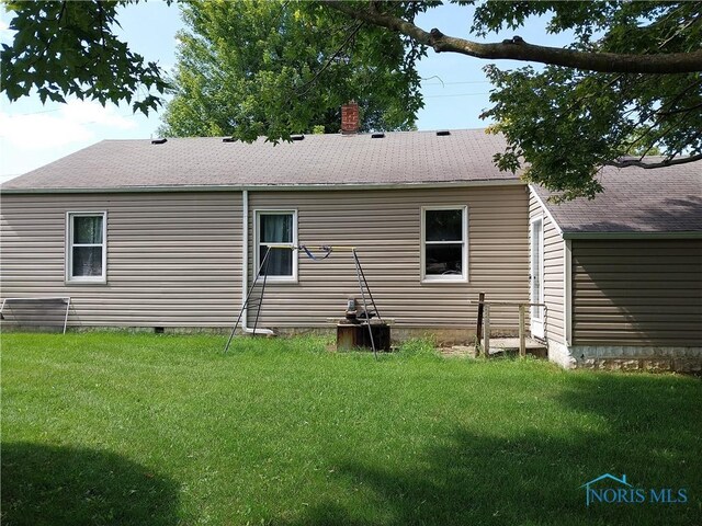 rear view of property featuring a yard