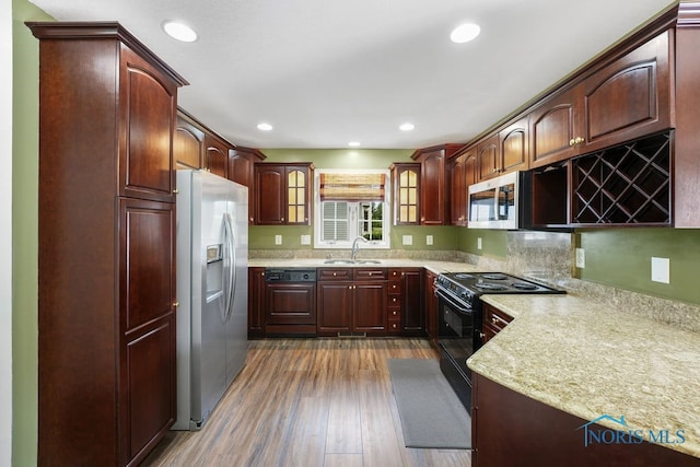 kitchen with appliances with stainless steel finishes, dark hardwood / wood-style floors, and sink