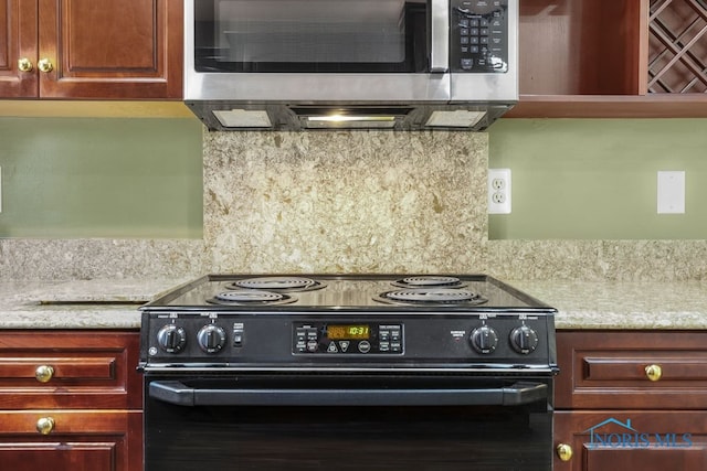 kitchen featuring black electric range and light stone countertops