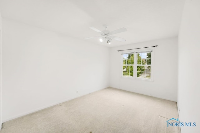 spare room with ceiling fan and light carpet