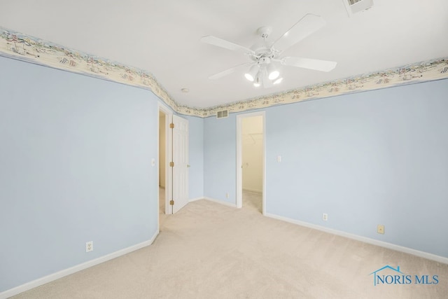 spare room featuring ceiling fan and light carpet