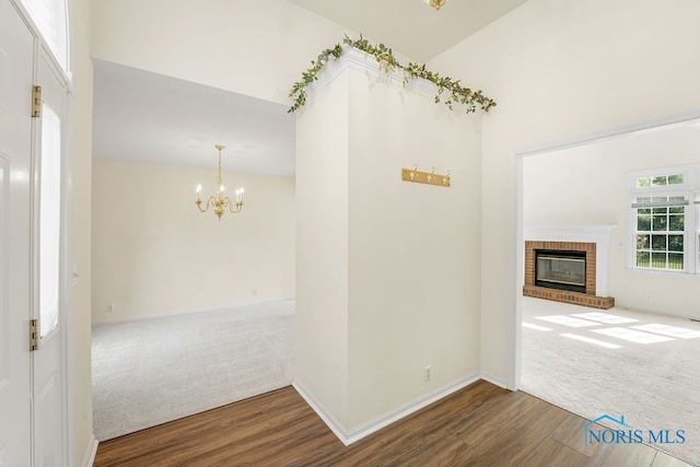 interior space with a notable chandelier, carpet, and lofted ceiling