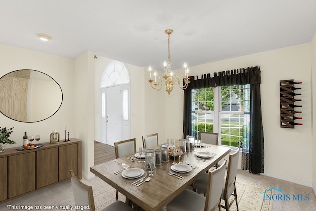 carpeted dining space with an inviting chandelier