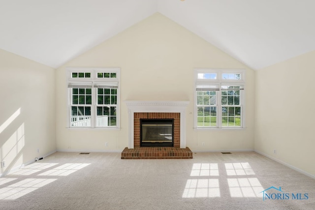 unfurnished living room featuring a fireplace, high vaulted ceiling, and light carpet