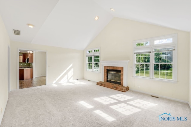 unfurnished living room with high vaulted ceiling, light colored carpet, and a fireplace