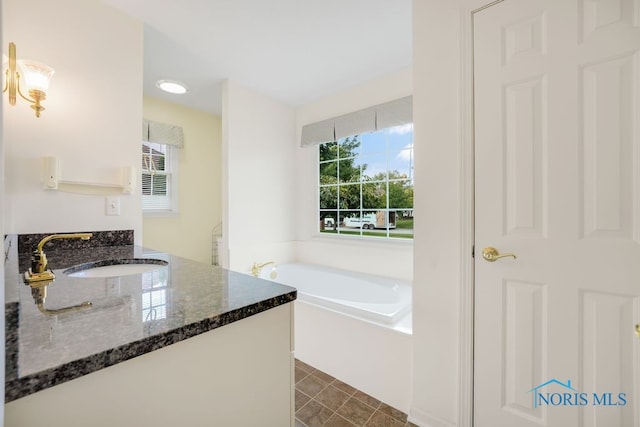 bathroom with a bath, tile patterned flooring, and vanity