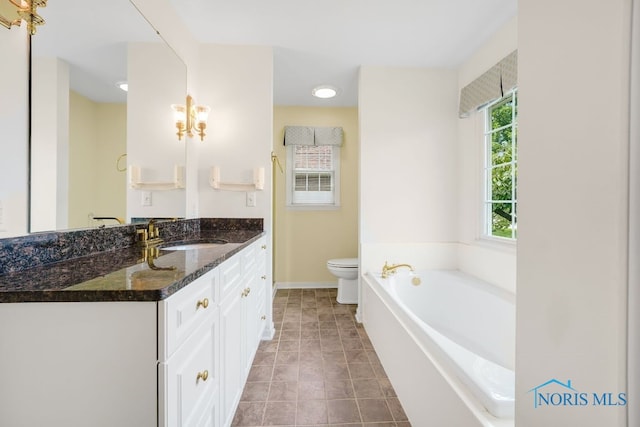 bathroom featuring a wealth of natural light, tile patterned flooring, vanity, and toilet