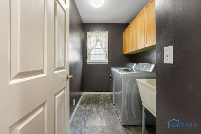 laundry room featuring washer and clothes dryer and cabinets