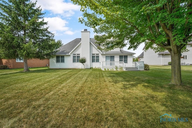 back of property featuring a lawn and a deck