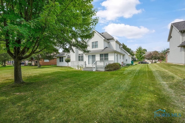 rear view of house featuring a yard