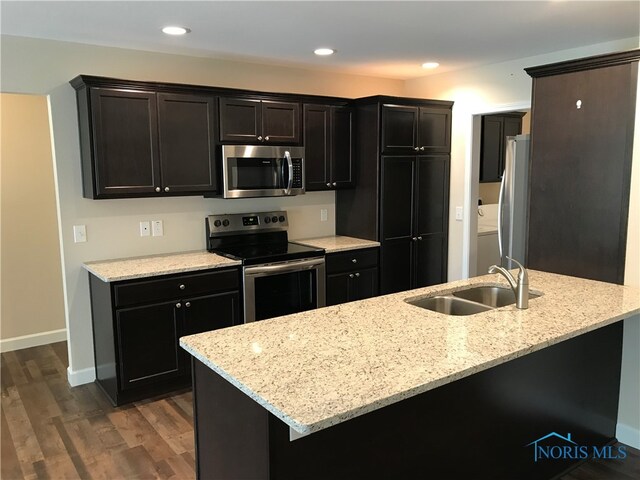 kitchen with hardwood / wood-style flooring, dark brown cabinetry, light stone counters, sink, and stainless steel appliances