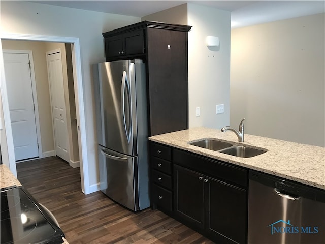 kitchen featuring sink, dark hardwood / wood-style floors, light stone counters, and stainless steel appliances