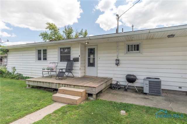 back of house featuring cooling unit, a deck, and a yard