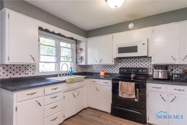 kitchen featuring backsplash, white cabinetry, and black electric range