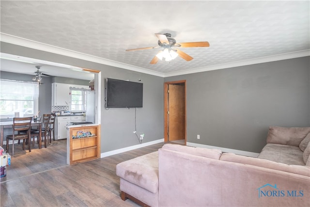 living room featuring crown molding, dark hardwood / wood-style flooring, and ceiling fan