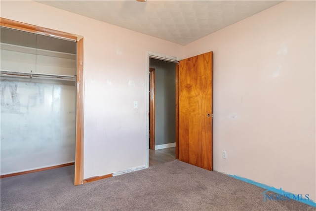 unfurnished bedroom with carpet flooring and a closet