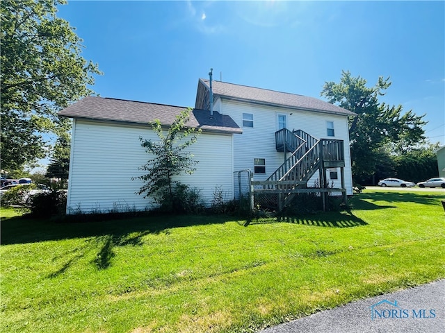 rear view of property featuring a yard